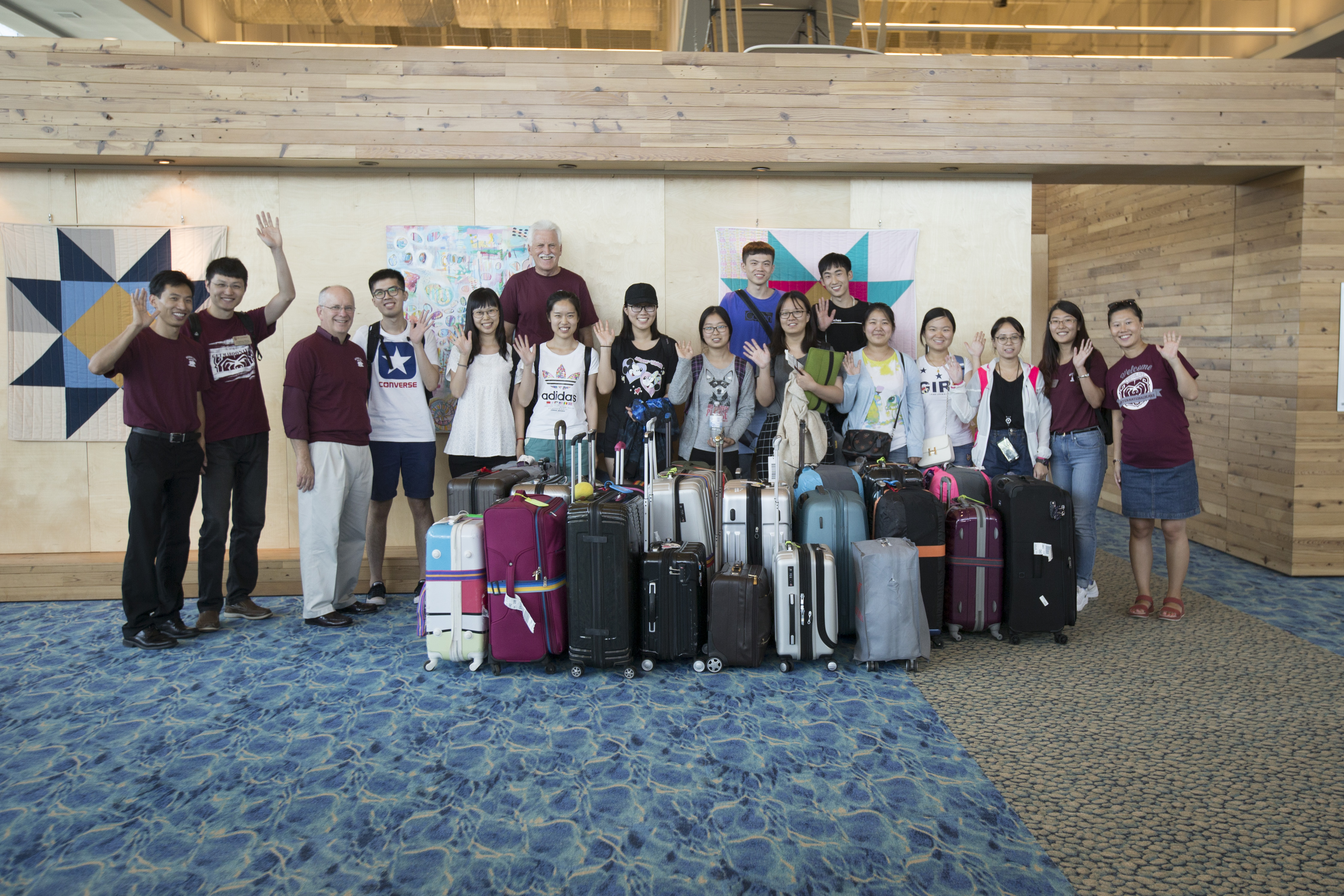 A group of students pose with luggage at the airport
